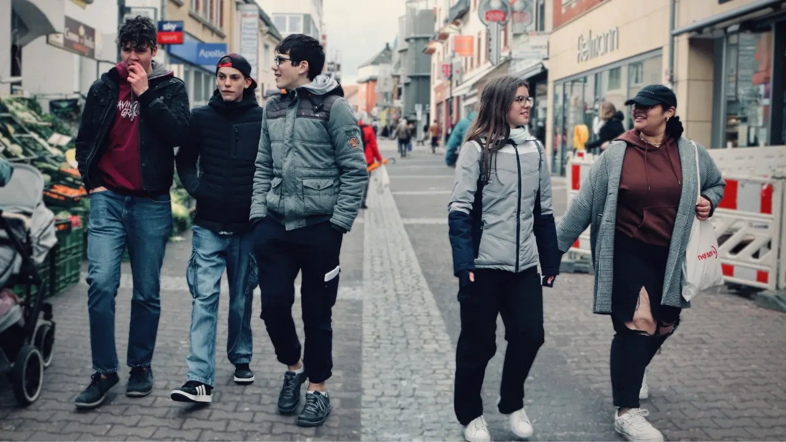 Teenager laufen eine Straße in Deutschland entlang