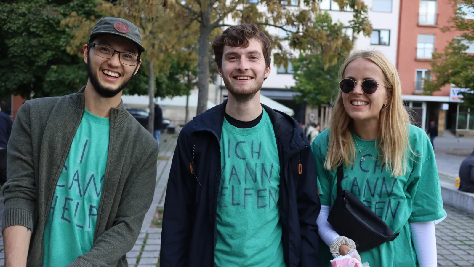 3 YWAM missionaries serving in the neighborhood wearing green 