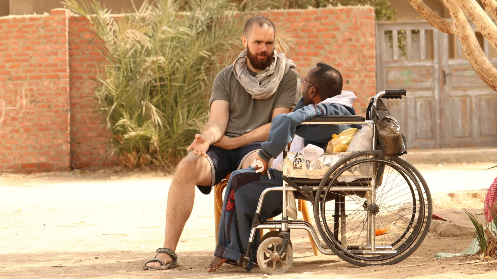 a YWAM missionary sitting next to a man and talking about the Gospel