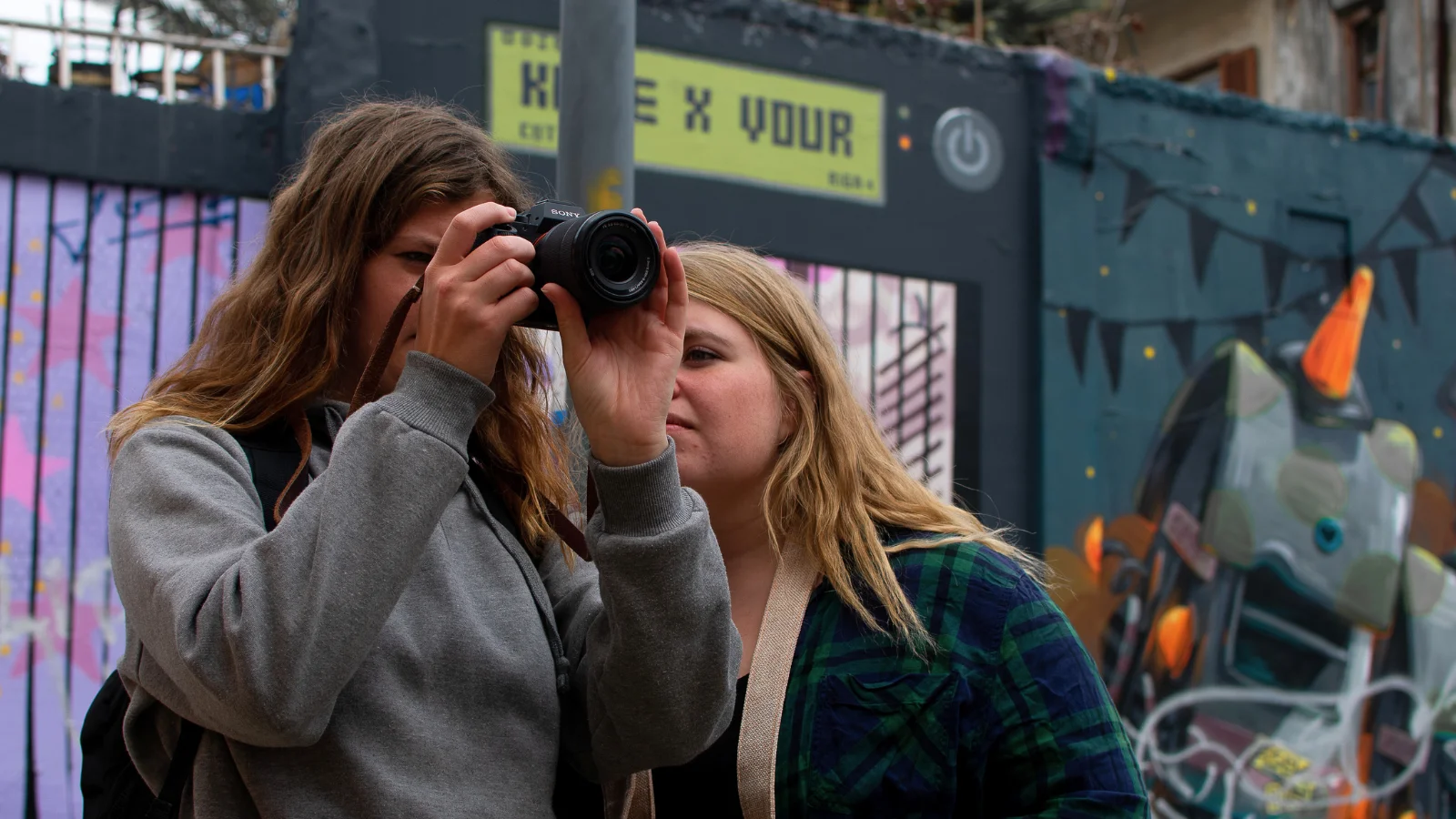 zwei JMEM-Missionare beim Fotografieren in einem städtischen Viertel